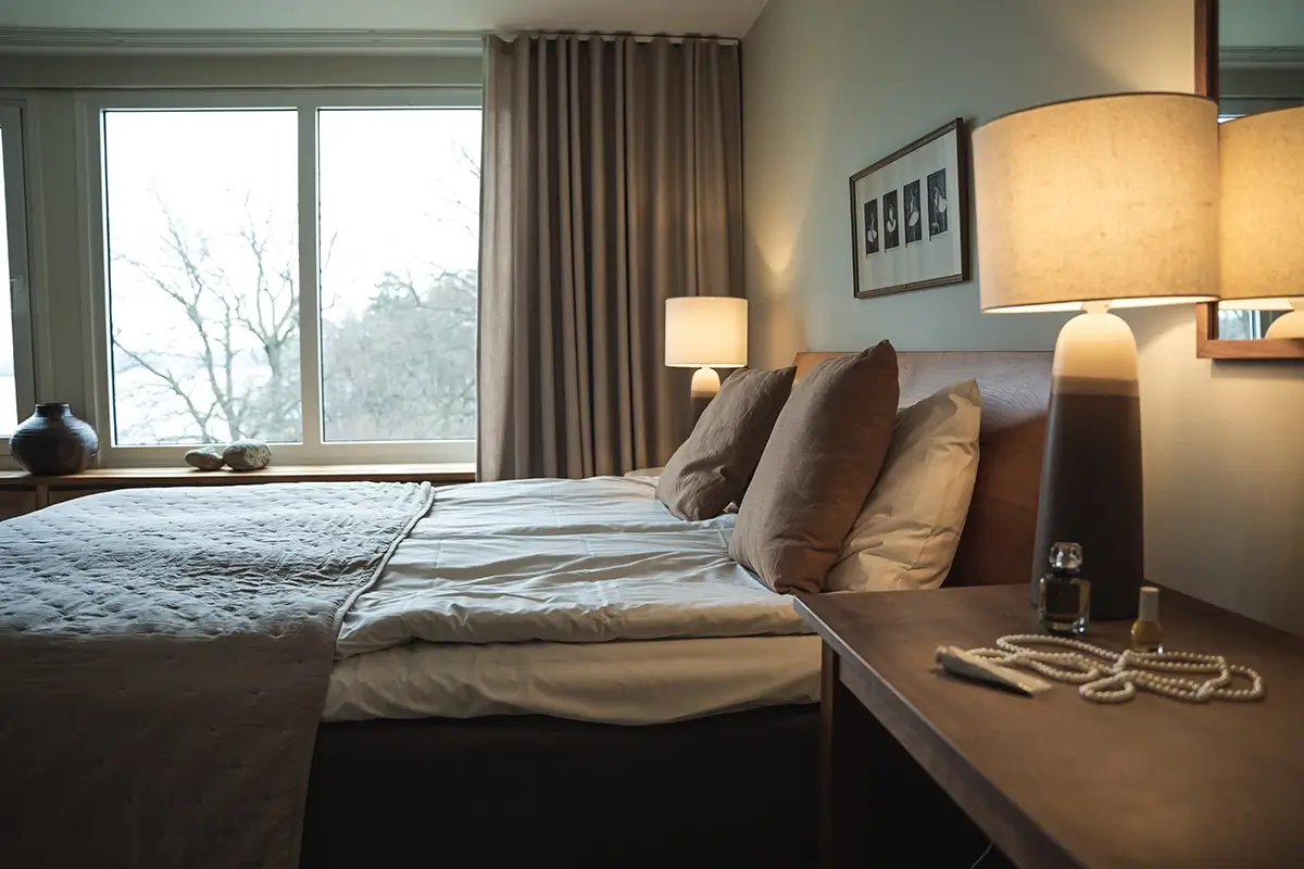 Behagligt hotellrum med bekväm dubbelsäng och vacker natur som skådas ifrån fönstret